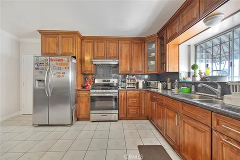 a kitchen with stainless steel appliances granite countertop a refrigerator and a sink