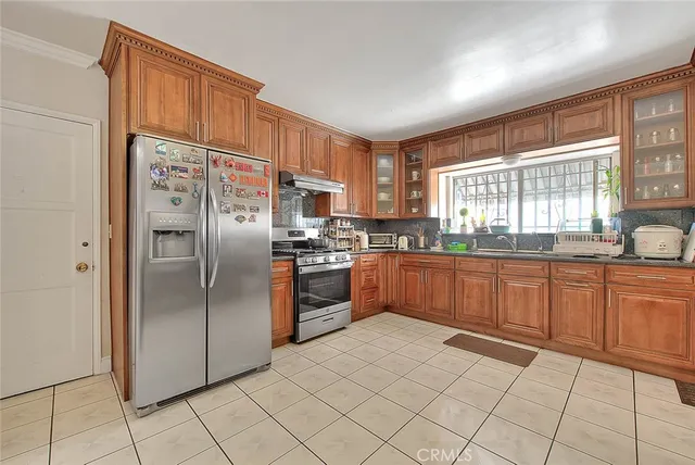 a kitchen with stainless steel appliances granite countertop a refrigerator and wooden cabinets