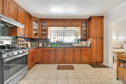 a kitchen with stainless steel appliances granite countertop a stove top oven a sink a counter space and cabinets
