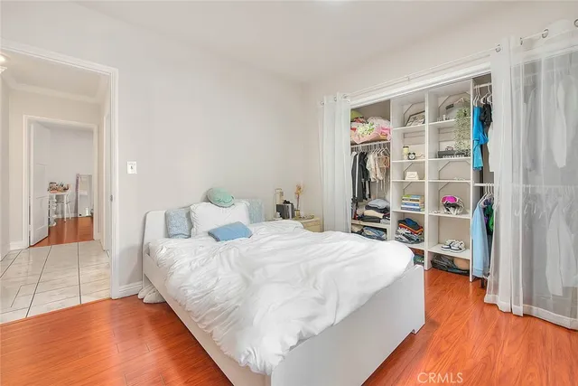 a bedroom with a bed and a wooden floor