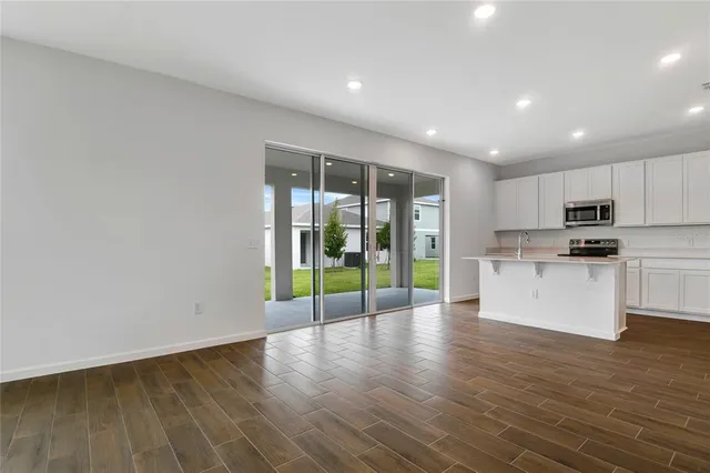 a view of kitchen with wooden floor and electronic appliances