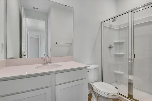 a bathroom with a sink toilet vanity and shower