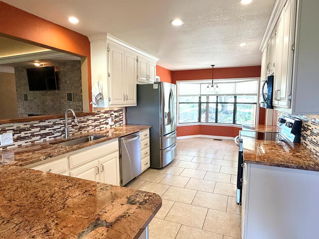 707 Rimrock Road Kerrville, TX 78028 - Photo 17 of 55 a kitchen with stainless steel appliances granite countertop a sink and a stove