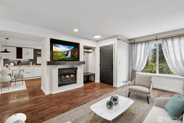 a living room with furniture a flat screen tv and a fireplace