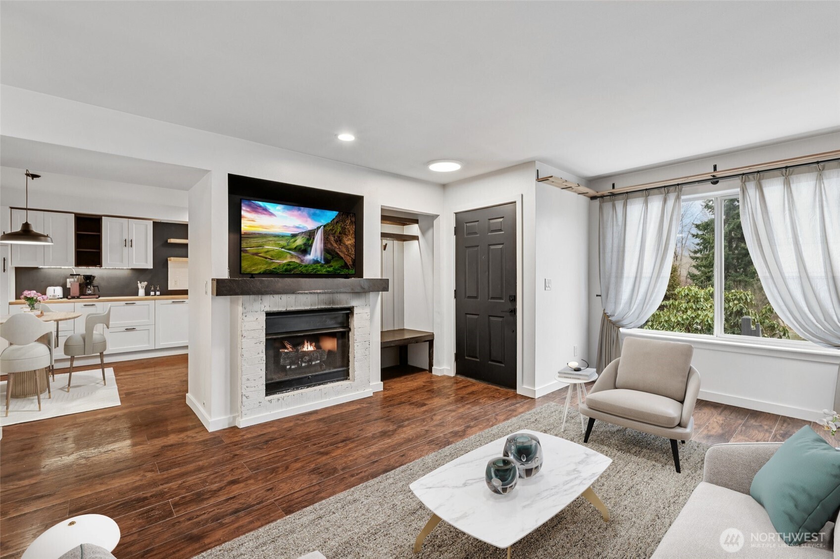 a living room with furniture a flat screen tv and a fireplace