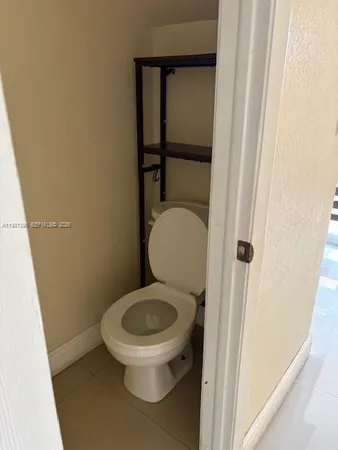 a white toilet sitting next to a shower
