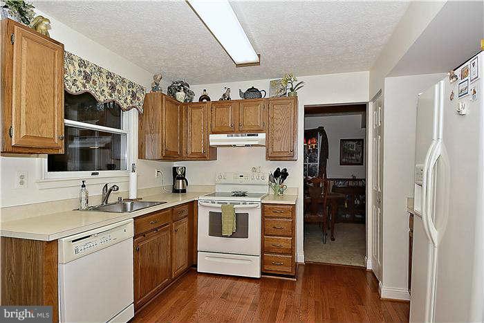 8102 Walton Road Severn, MD 21144 - Photo 11 of 30 a kitchen with a sink cabinets and wooden floor
