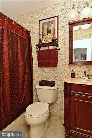 8102 Walton Road Severn, MD 21144 - Photo 19 of 30 a bathroom with a toilet a sink and mirror