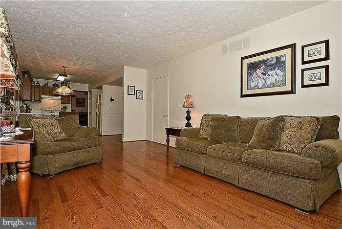 8102 Walton Road Severn, MD 21144 - Photo 5 of 30 a living room with couches and a dining table with wooden floor