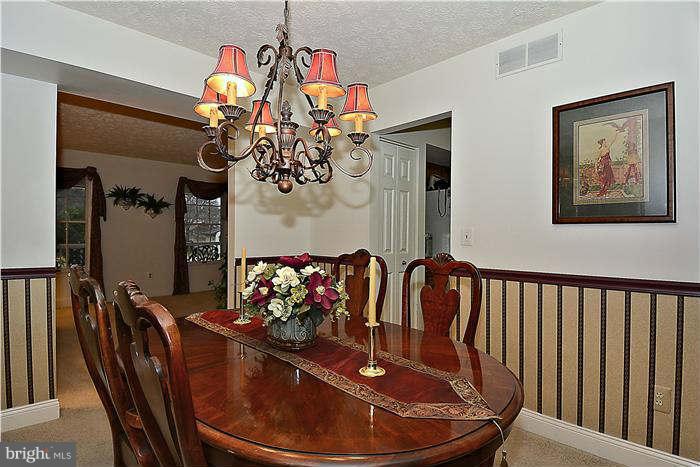 8102 Walton Road Severn, MD 21144 - Photo 7 of 30 a view of a dining room with furniture wooden floor and a chandelier