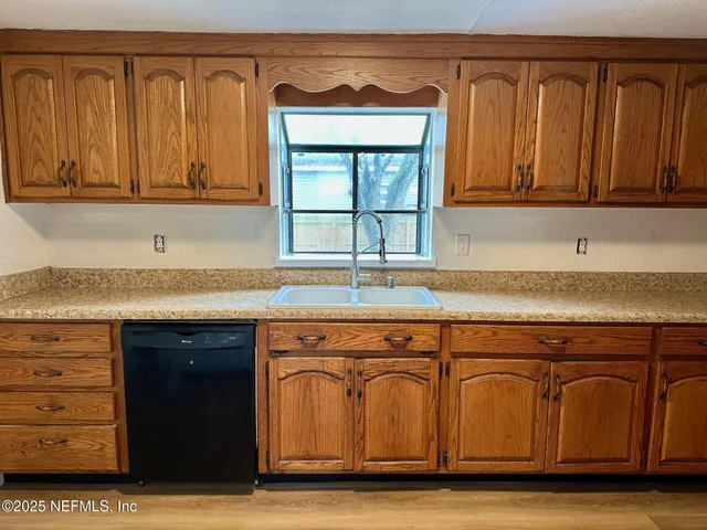 a kitchen with stainless steel appliances granite countertop a sink and cabinets with wooden floor