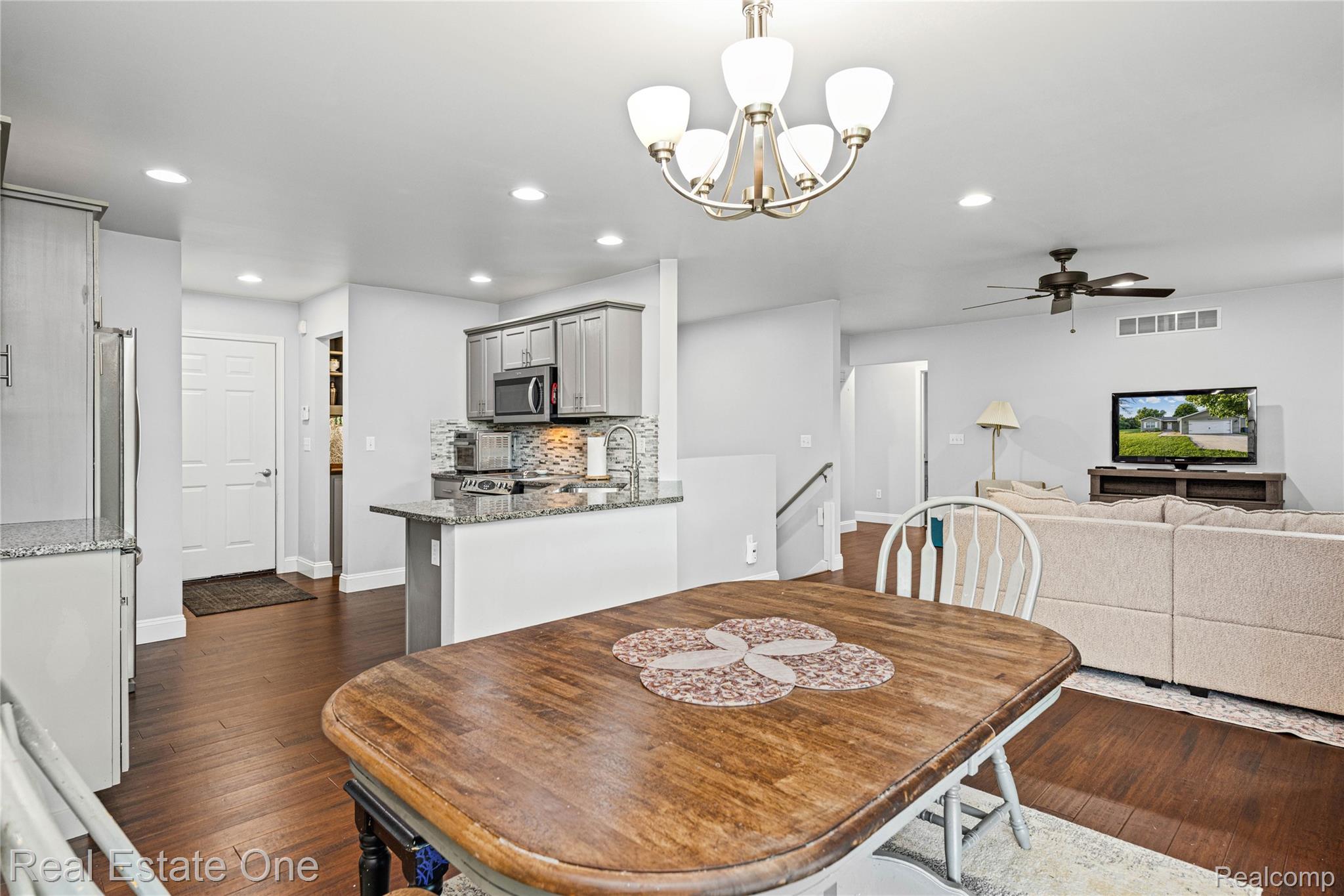 2479 Gibson Road Grand Blanc, MI 48439 - Photo 18 of 55 Open-concept living space featuring wood-finish flooring, recessed lighting, and a modern chandelier