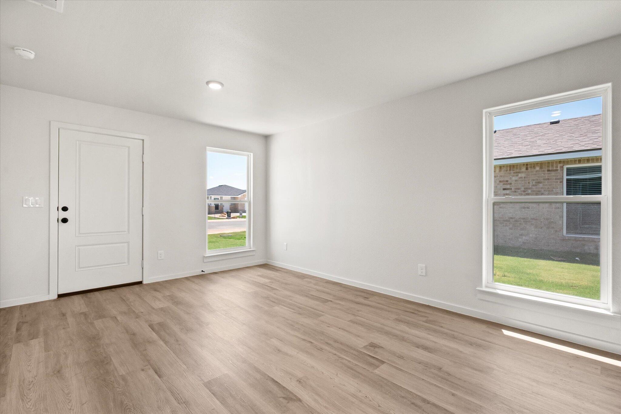 8312 25th Street Lubbock, TX 79407 - Photo 7 of 17 a view of an empty room with wooden floor and a window
