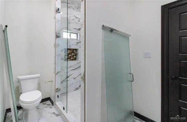 a bathroom with a toilet and a shower