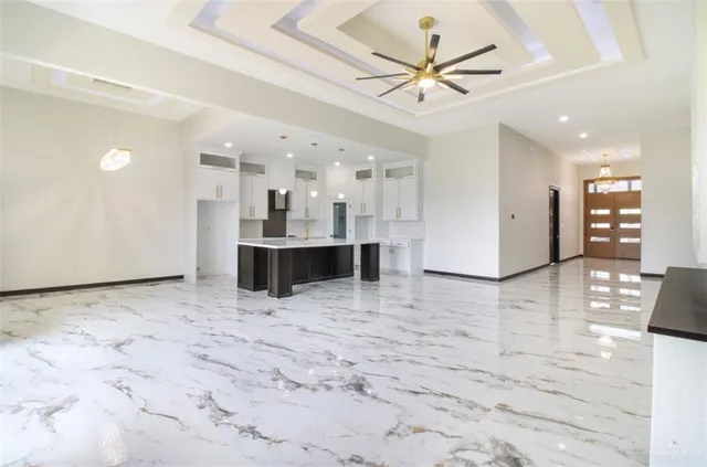 a view of kitchen and empty room with wooden floor