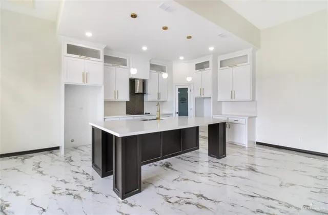a large white kitchen with a sink and cabinets