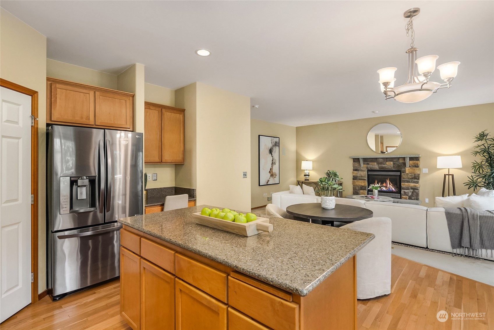 307 197th Place Southwest Bothell, WA 98012 - Photo 10 of 30 a kitchen with stainless steel appliances granite countertop a refrigerator a sink dishwasher a oven a dining table and chairs with wooden floor