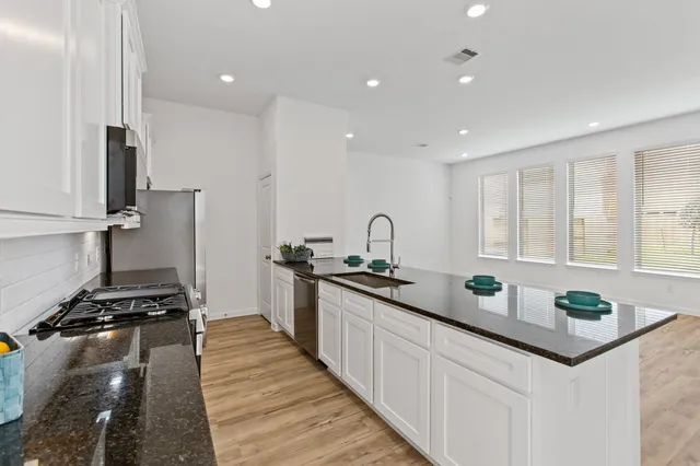a kitchen with stainless steel appliances a sink stove and cabinets