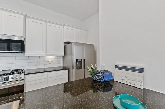 a kitchen with stainless steel appliances a refrigerator sink and stove