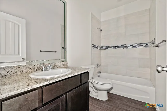 a bathroom with a granite countertop sink toilet a mirror and shower