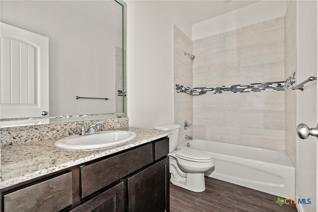 5219 Rose Gdn Loop Killeen, TX 76542 - Photo 11 of 19 a bathroom with a granite countertop sink toilet a mirror and shower