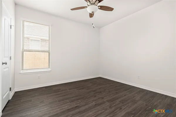 an empty room with a window and wooden floor