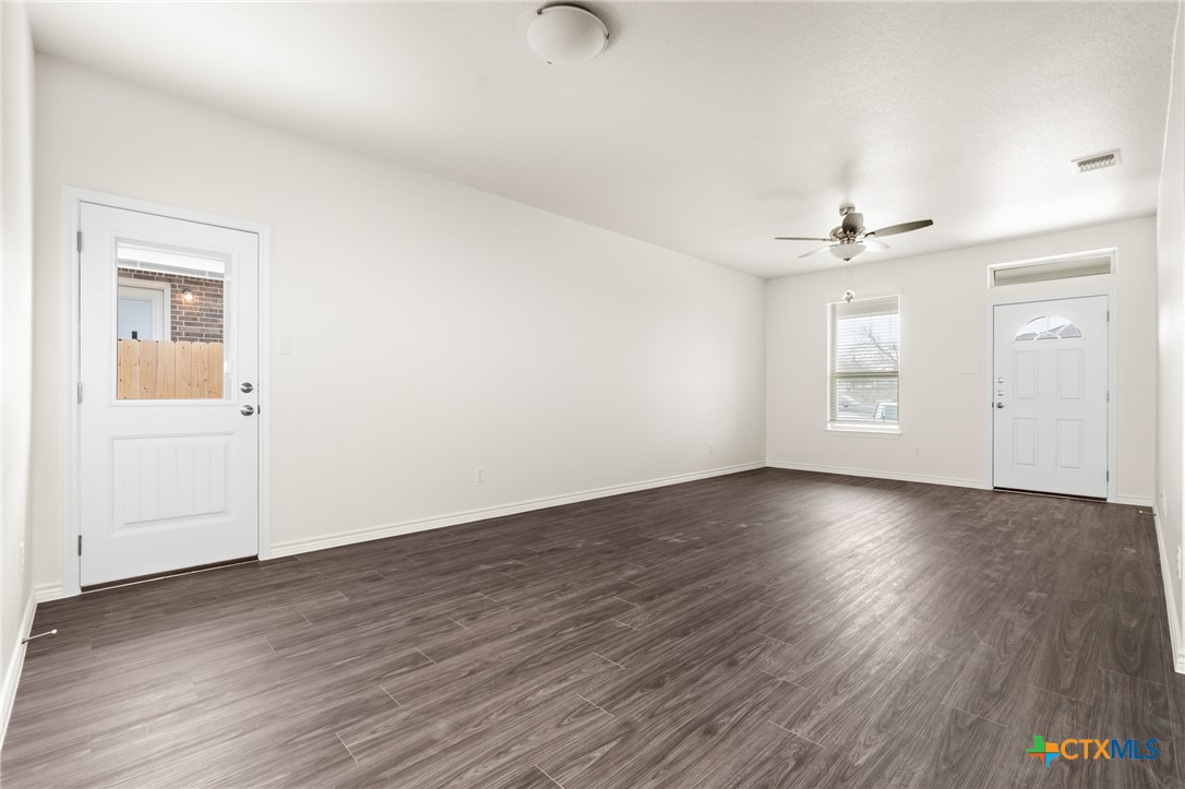 5219 Rose Gdn Loop Killeen, TX 76542 - Photo 4 of 19 an empty room with wooden floor chandelier and windows