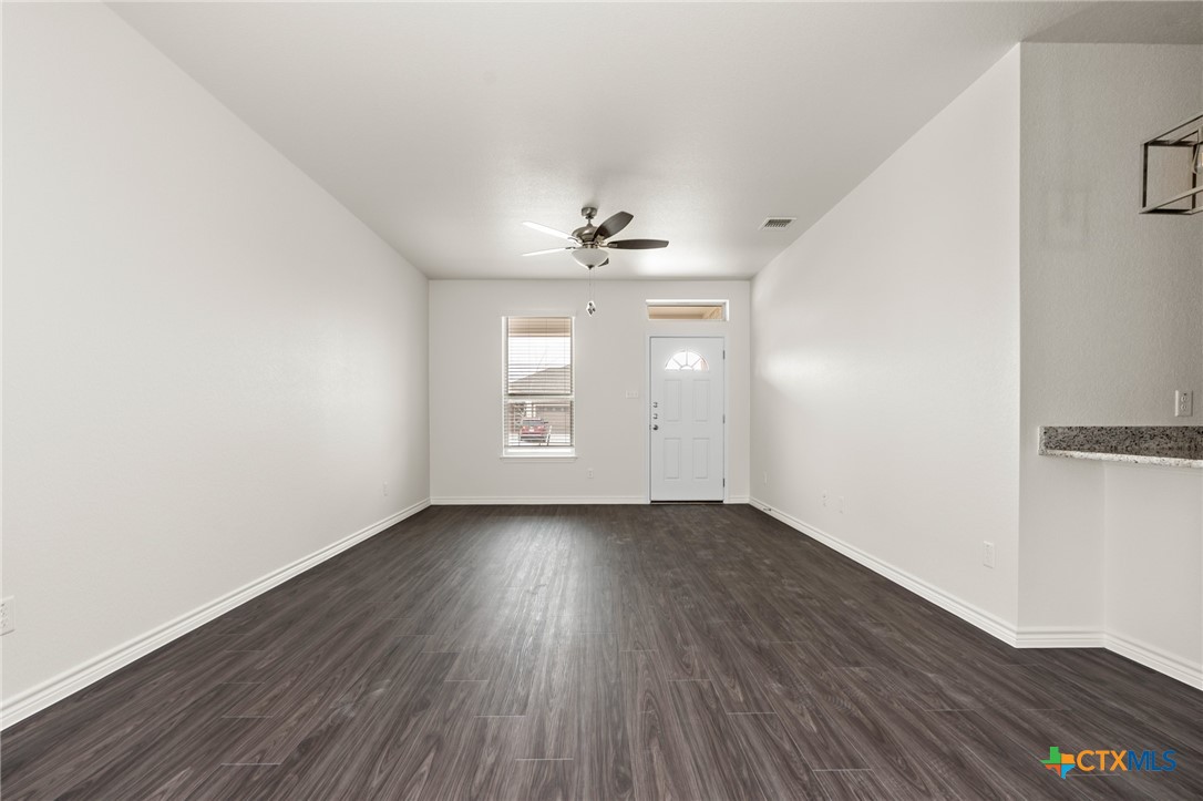 5219 Rose Gdn Loop Killeen, TX 76542 - Photo 5 of 19 an empty room with wooden floor chandelier fan and windows