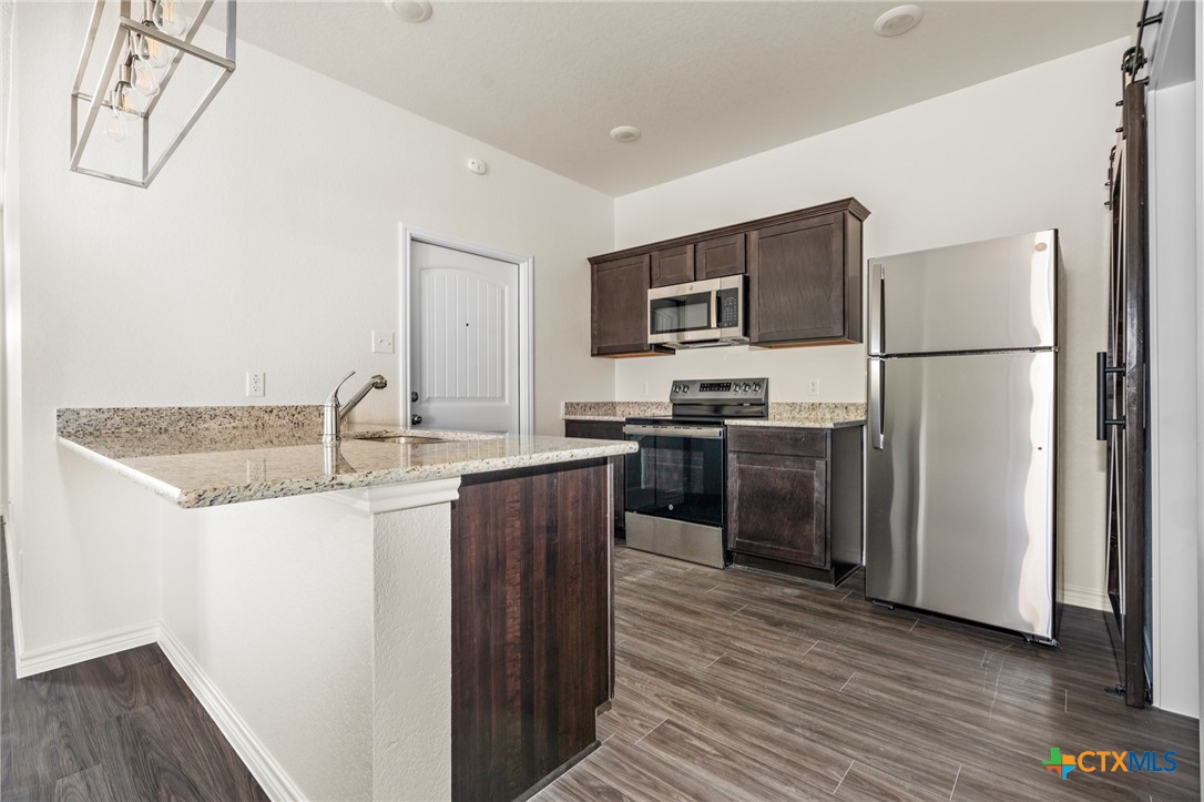 5219 Rose Gdn Loop Killeen, TX 76542 - Photo 7 of 19 a kitchen with kitchen island a sink stainless steel appliances and refrigerator