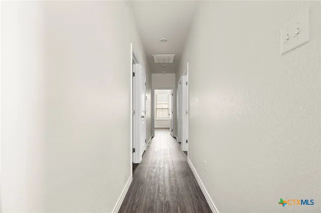 a view of a room with wooden floor