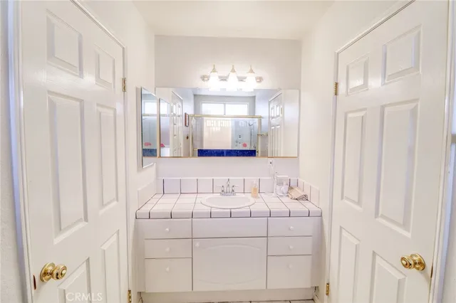 a bathroom with a sink vanity mirror and shower