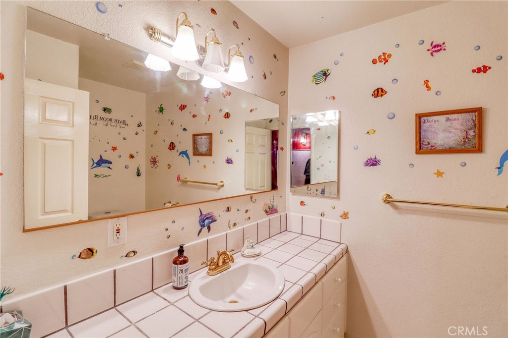 20430 Rancherias Road Apple Valley, CA 92307 - Photo 21 of 48 a bathroom with a sink vanity mirror and shower