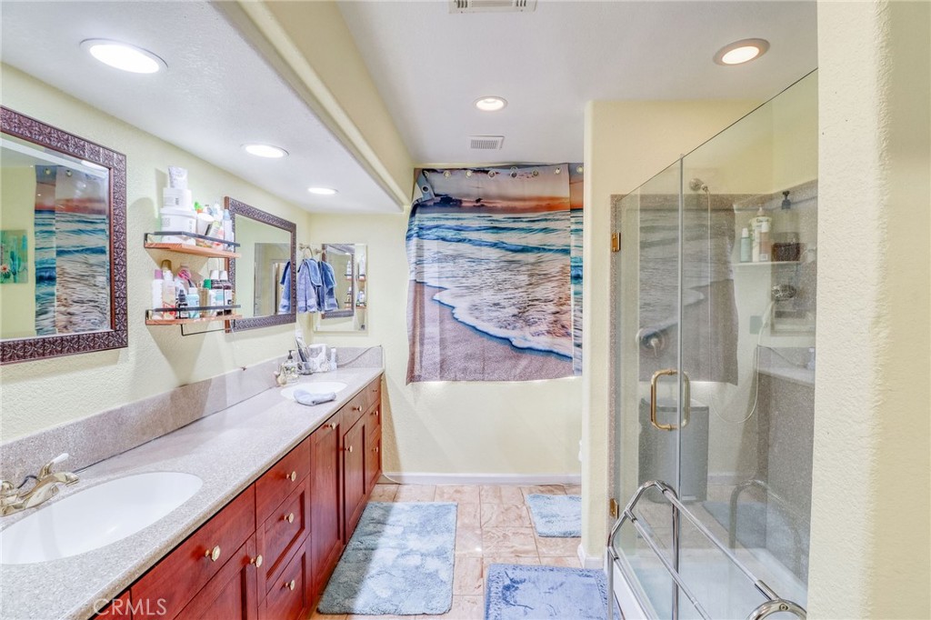 20430 Rancherias Road Apple Valley, CA 92307 - Photo 28 of 48 a bathroom with double vanity and a shower