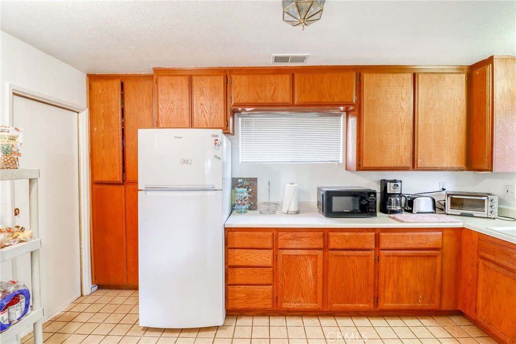 20430 Rancherias Road Apple Valley, CA 92307 - Photo 30 of 48 a kitchen with stainless steel appliances a refrigerator sink and cabinets