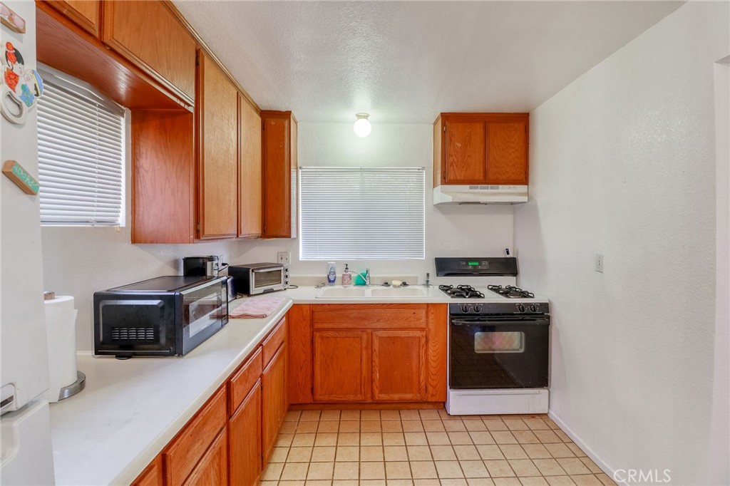 20430 Rancherias Road Apple Valley, CA 92307 - Photo 32 of 48 a kitchen with stainless steel appliances granite countertop a sink stove and cabinets