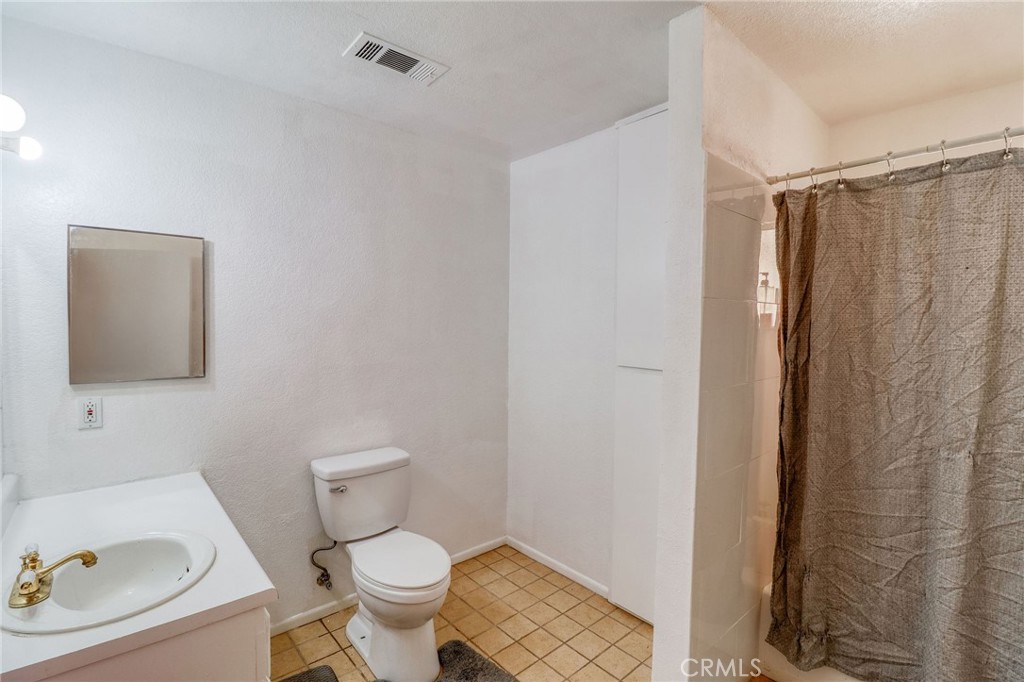 20430 Rancherias Road Apple Valley, CA 92307 - Photo 34 of 48 a white toilet sitting next to a bathroom sink and a shower