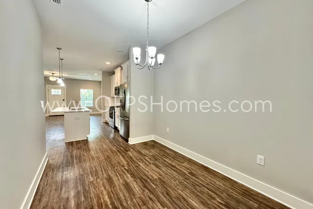a view of a room with wooden floor and kitchen view