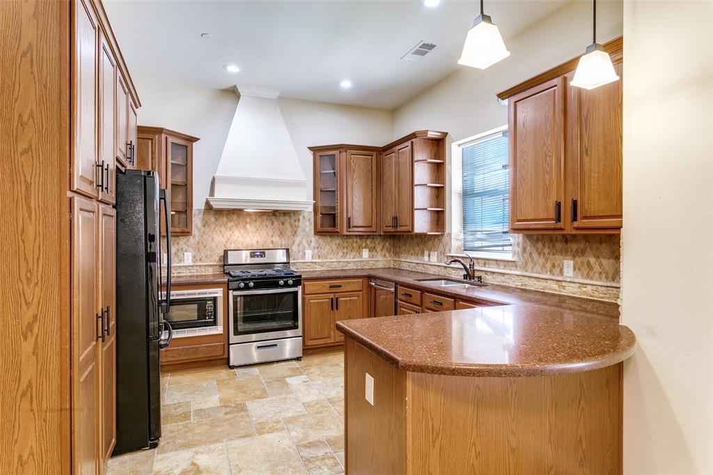 8608 Augustine Road Irving, TX 75063 - Photo 12 of 26 a kitchen with stainless steel appliances granite countertop a sink a stove and a refrigerator