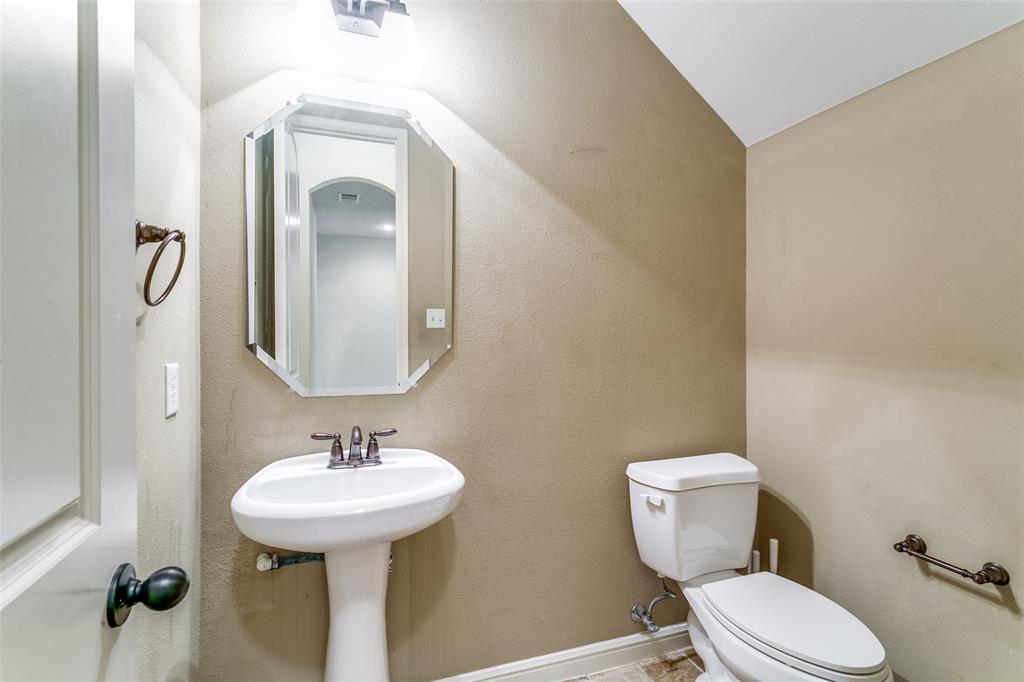 8608 Augustine Road Irving, TX 75063 - Photo 25 of 26 a bathroom with a toilet sink and mirror