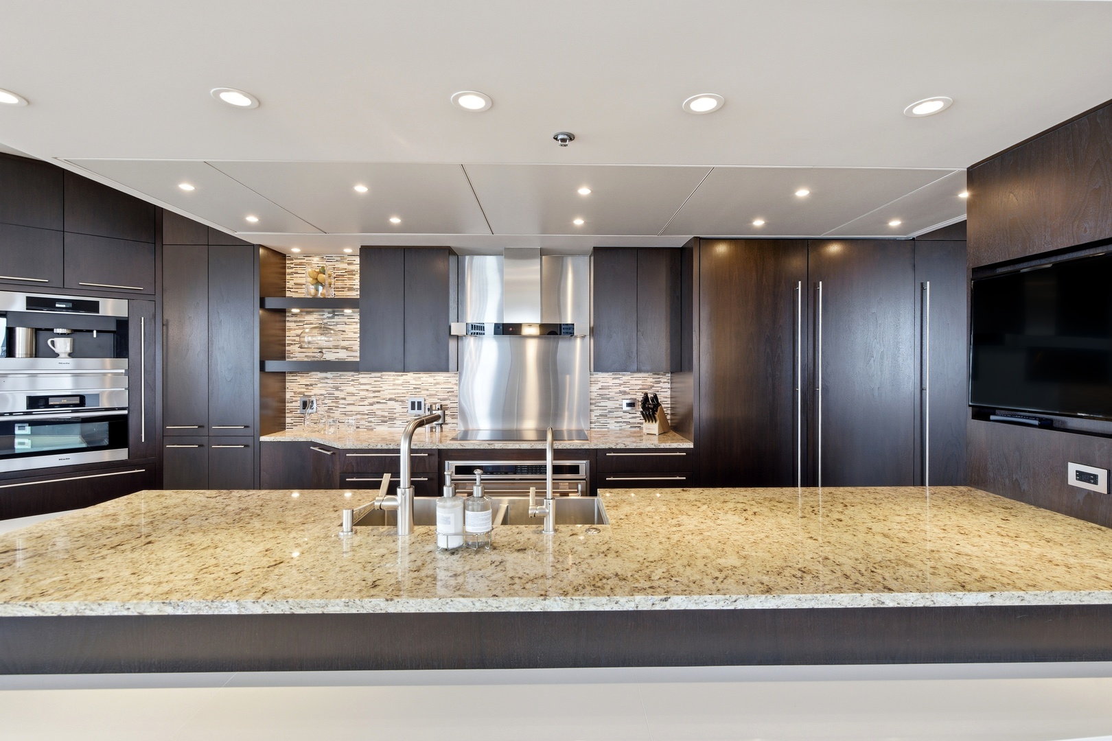 161 East Chicago Avenue, Unit 53A Chicago, IL 60611 - Photo 14 of 47 a large kitchen with kitchen island granite countertop a large counter top stainless steel appliances and cabinets