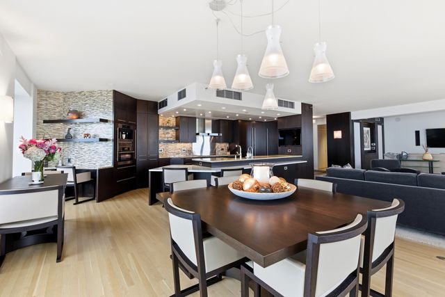 a view of a dining room with furniture a kitchen and chandelier