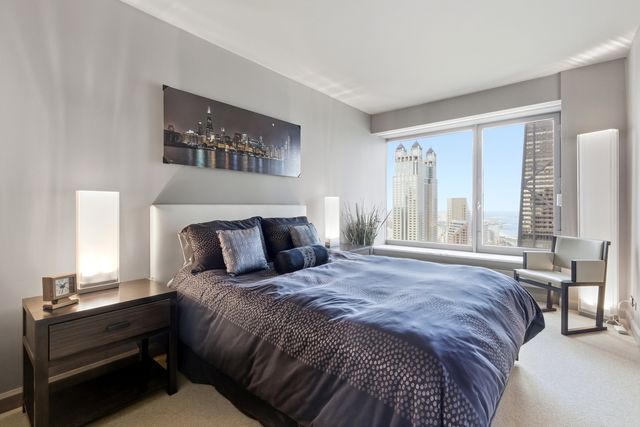 a bedroom with a bed tv and a chair