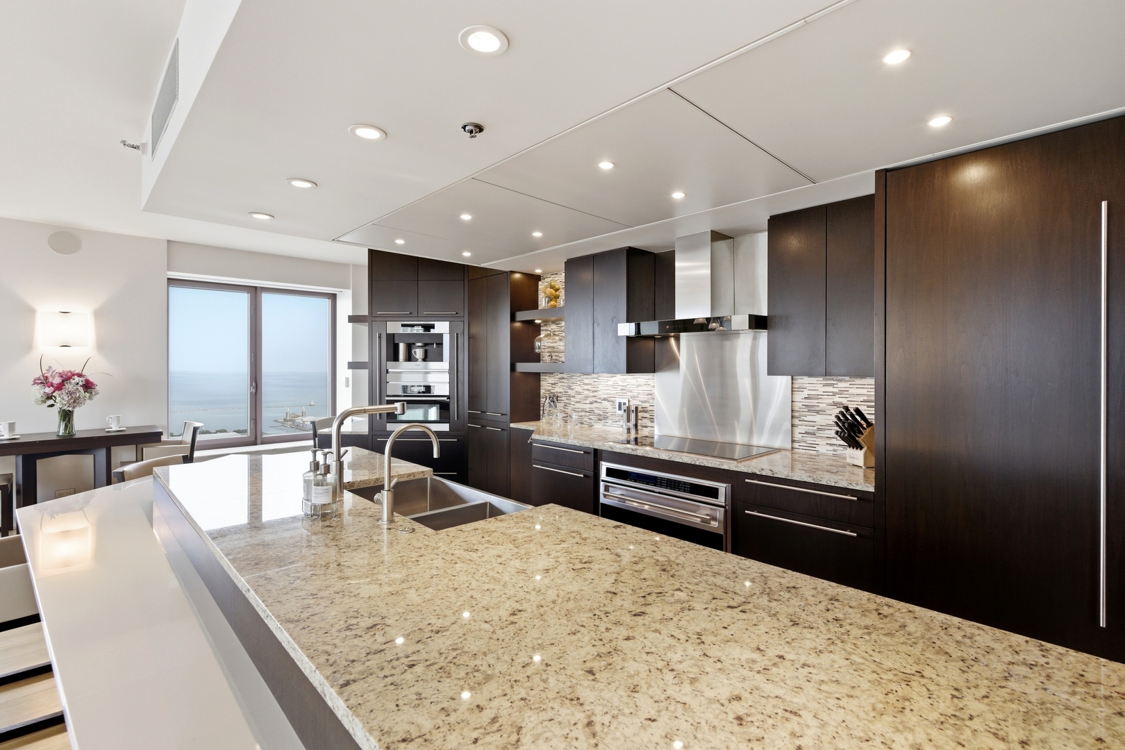 161 East Chicago Avenue, Unit 53A Chicago, IL 60611 - Photo 10 of 47 a kitchen with stainless steel appliances kitchen island granite countertop a refrigerator and a sink