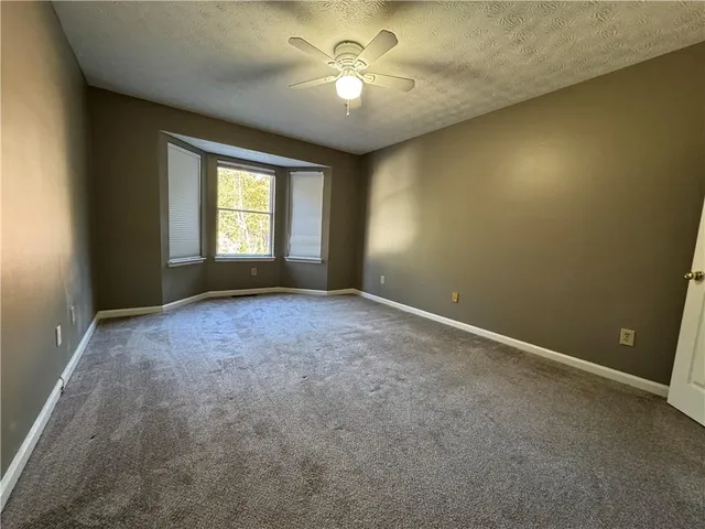 a view of room with a ceiling fan and window