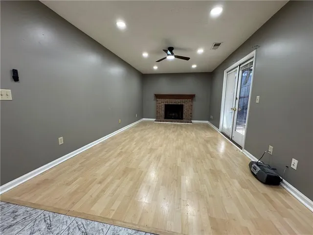 an empty room with wooden floor and balcony