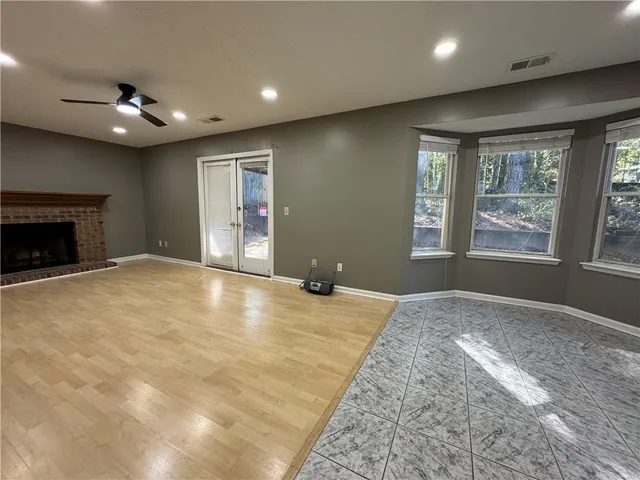 an empty room with windows and fireplace
