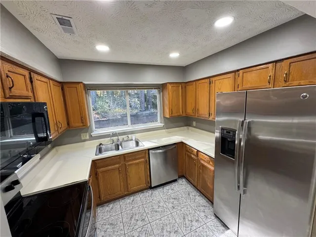 a kitchen with a sink stove and refrigerator