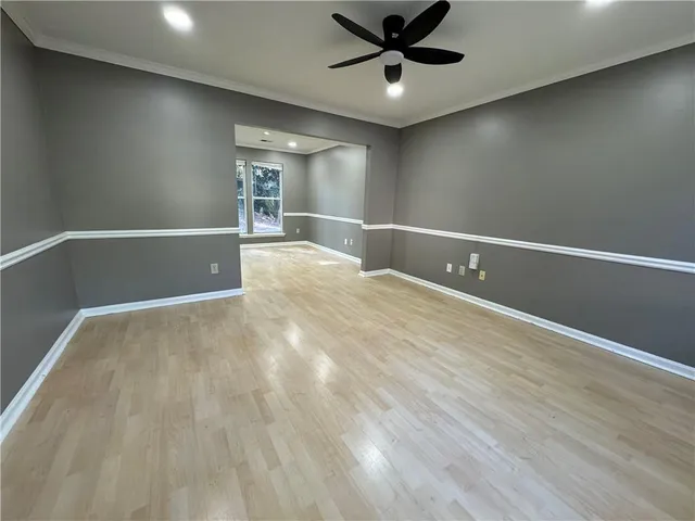 a view of a livingroom with a ceiling fan and hardwood floor
