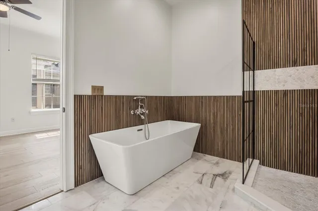 an empty room with wooden floor cabinet and windows