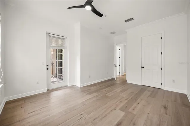 a large white kitchen with kitchen island a sink wooden floor and stainless steel appliances